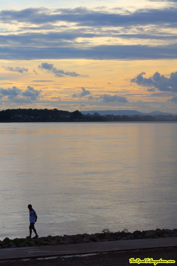 vientiane sunset man walking Man walking along the Mekong River at Sunset in Vientiane, Laos
